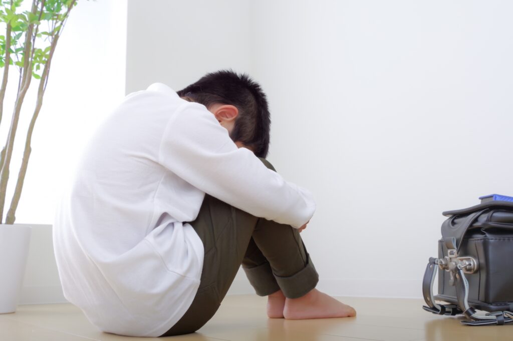 膝を抱え込みしゃがむ男性